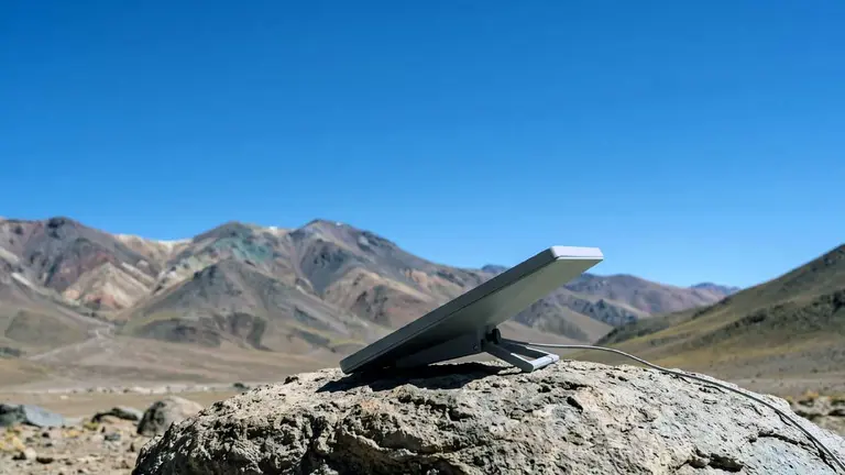 La antena compacta Starlink Mini apoyada sobre una roca en el norte argentino, que muestra su tamaño reducido y el pie de soporte metálico desplegado. Imagen creada con inteligencia artificial IA