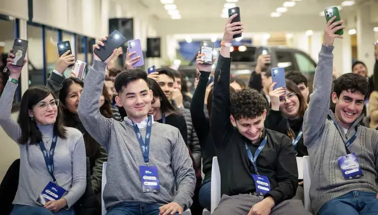 cuatro jóvenes levantan celulares. foto oficial ford