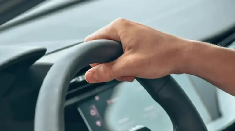 Mitad de volante con mano arriba. 
