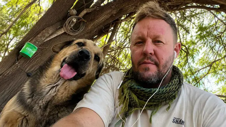 Eduardo Groh Riemersma posa junto a un perro en El Montecito de los Canichones, el refugio que creó en Santiago del Estero para rescatar animales abandonados y maltratados