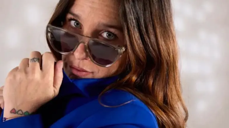 Juana Repetto posando con un traje azul y anteojos