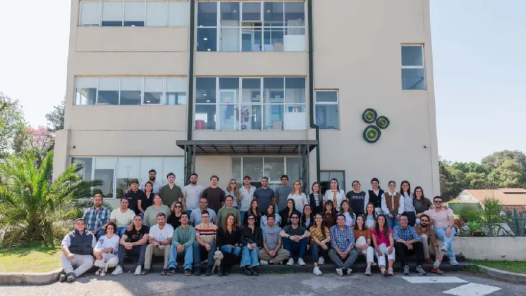 Grupo de personas, en su mayoría jóvenes, posando frente al edificio de la empresa PunaBio 