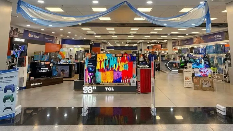 El frente de un local de una cadena de electrodomésticos, con televisores y otros productos exhibidos
