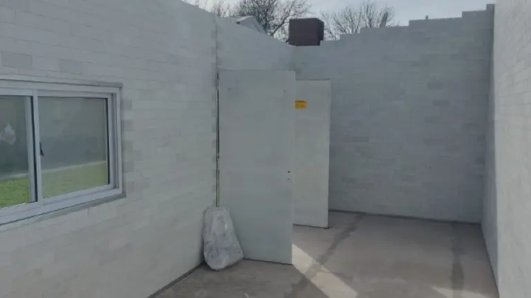 Paredes de una casa en construcción realizada con ladrillos sustentables de color blanco y una ventana 