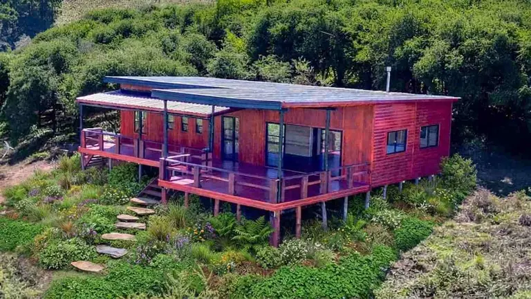 Una imagen aérea de una cabaña de madera, ya instalada en un terreno. 