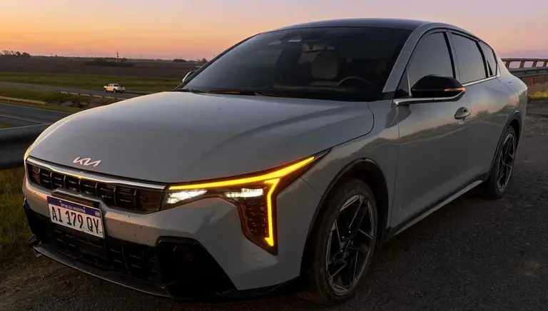 kia k4 de frente y lateral con atardecer de fondo foto ipro