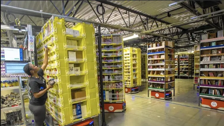 Cómo colaboran los robots con los empleados en los depósitos gigantes de Amazon