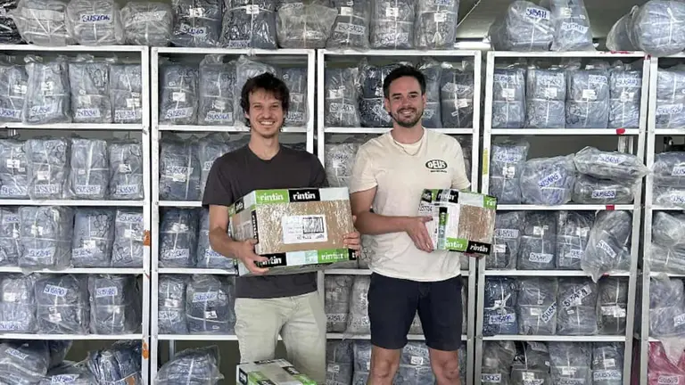 dos personas sosteniendo cajas en un deposito