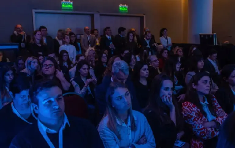 Grupo de personas atentas en un auditorio
