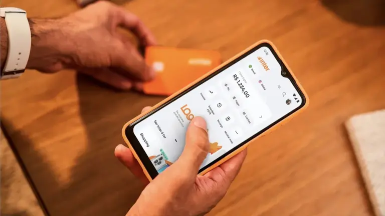 Usuario sostiene un celular con la aplicación de Inter