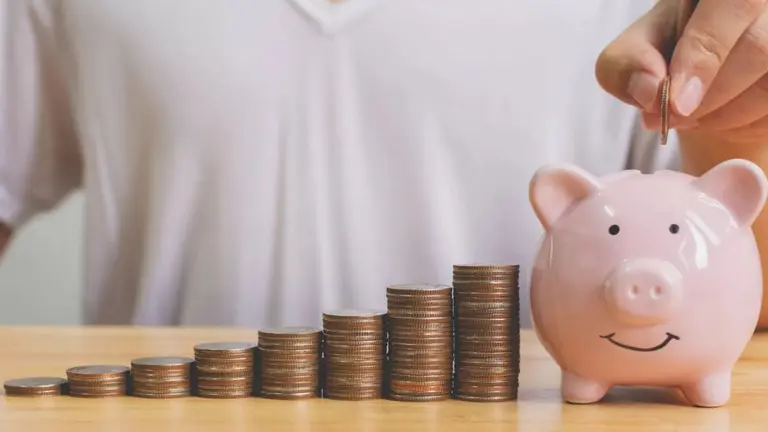 un hombre suma monedas a su alcancía