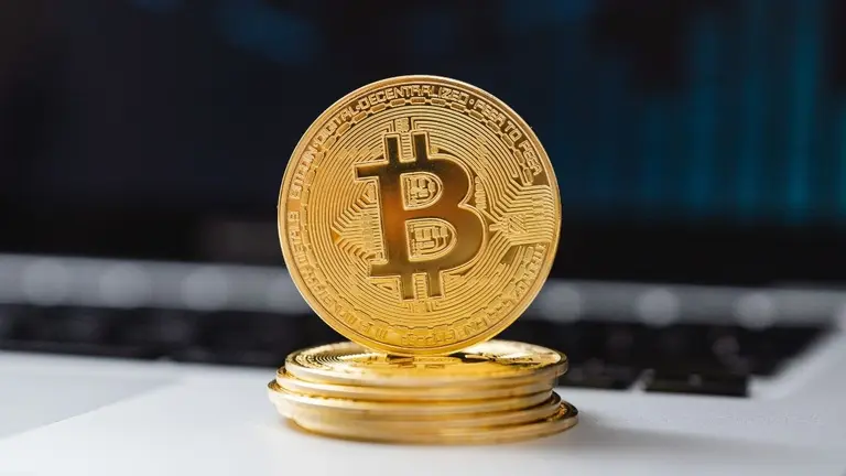 Una moneda de Bitcoin sobre una computadora de una empresa