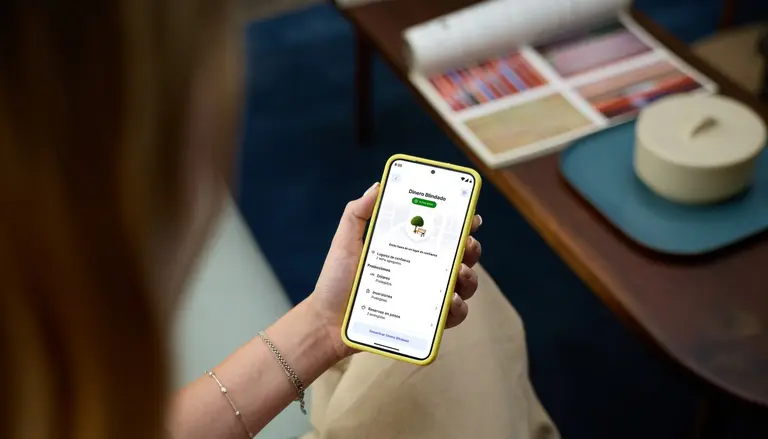 usuaria observa la función dinero blindado en la pantalla de su celular