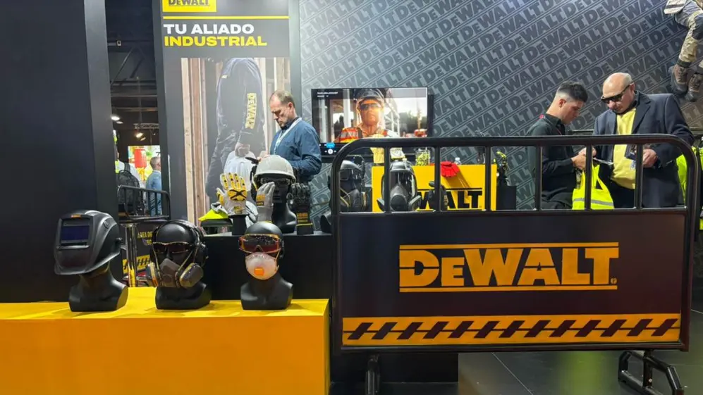Hay un stand DeWALT en una feria industrial, donde se exhiben equipos de protección personal