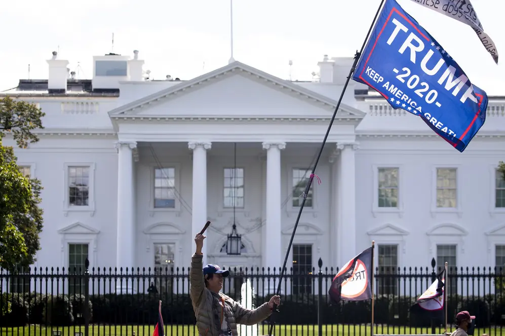 Una persona ondea una bandera de Trump 2020 frente a la Casa Blanca