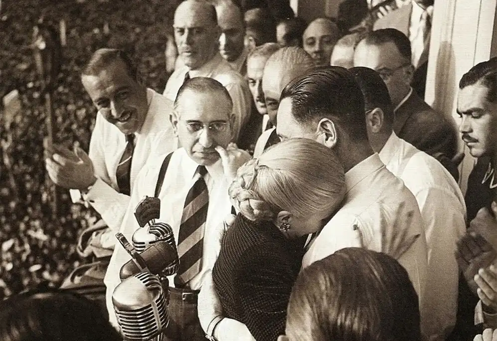 Juan Perón abraza a Eva Duarte, su mujer, el día del Renunciamiento. Los mira Ángel Borlenghi.
