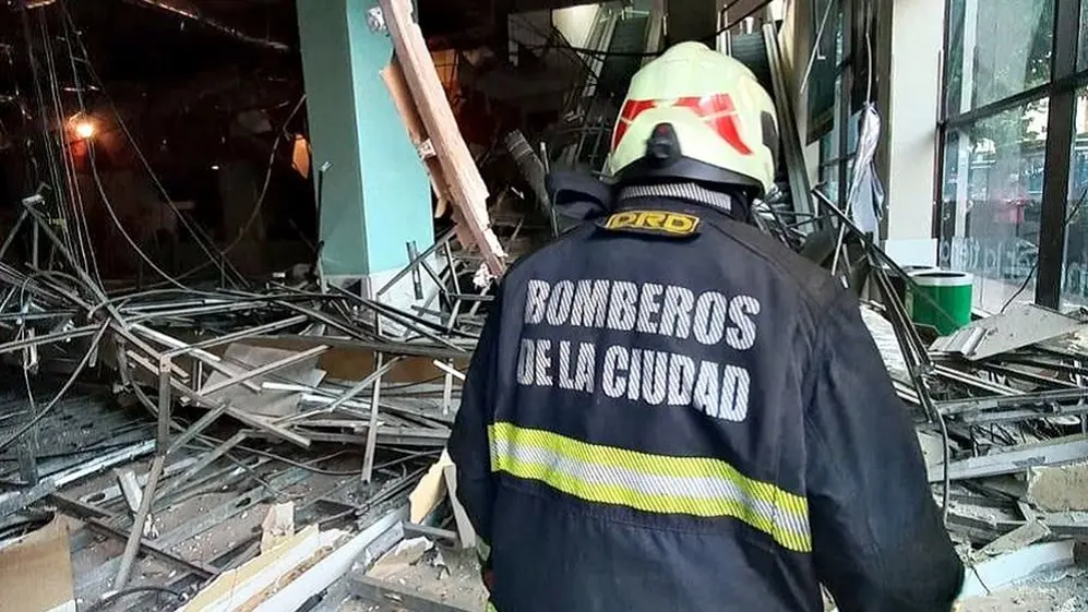 Bomberos de la Ciudad examinan el techo colapsado.