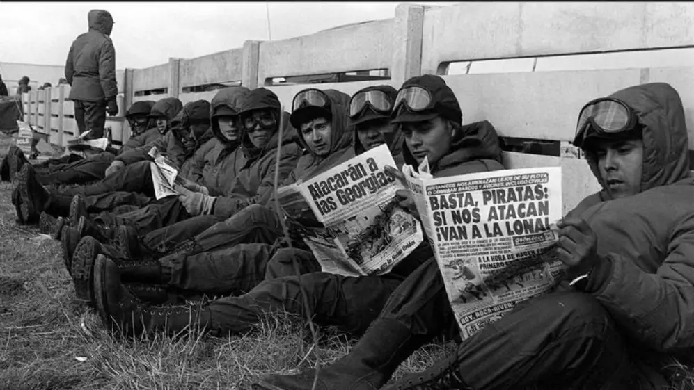 Soldados en la Guerra de Malvinas leen diarios con noticias sobre el conflicto bélico.