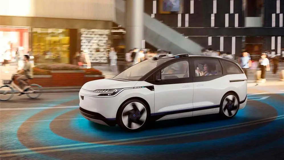 Auto autónomo blanco circula por una ciudad con sensores y tecnología de conducción inteligente