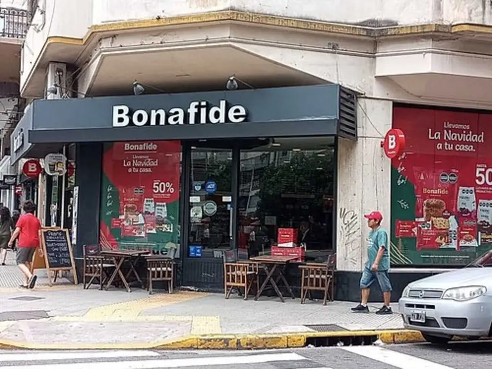Fachada de una sucursal de Bonafide en una esquina, con mesas y sillas sobre la vereda