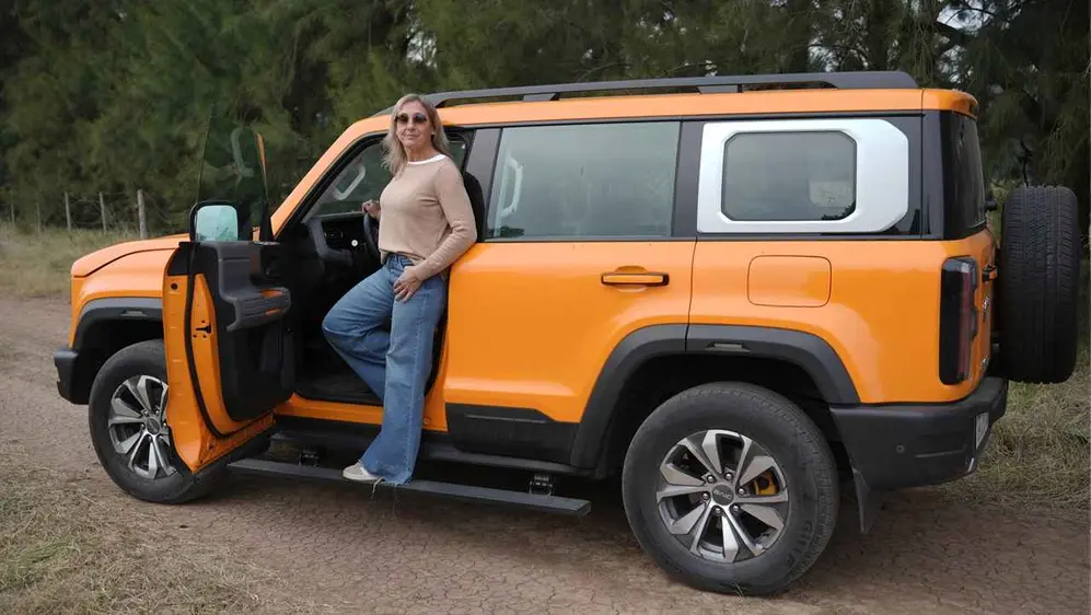 Guillermina Fossati en el estribo del Baic BJ40 Pro sobre camino de tierra. Foto iProfesional.