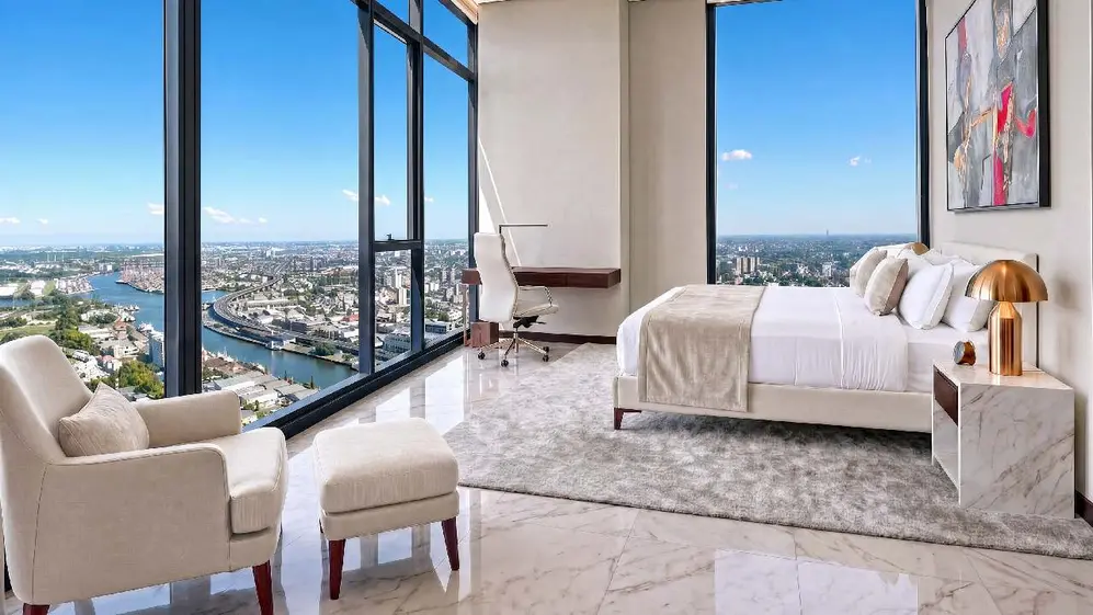 Hbitacion con cama, escritorio, sillos y mesitas con vista a Puerto Madero