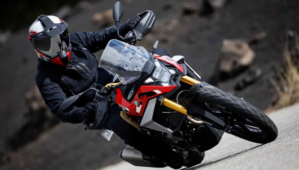 Piloto maneja moto GS450 inclinado. Foto oficial.