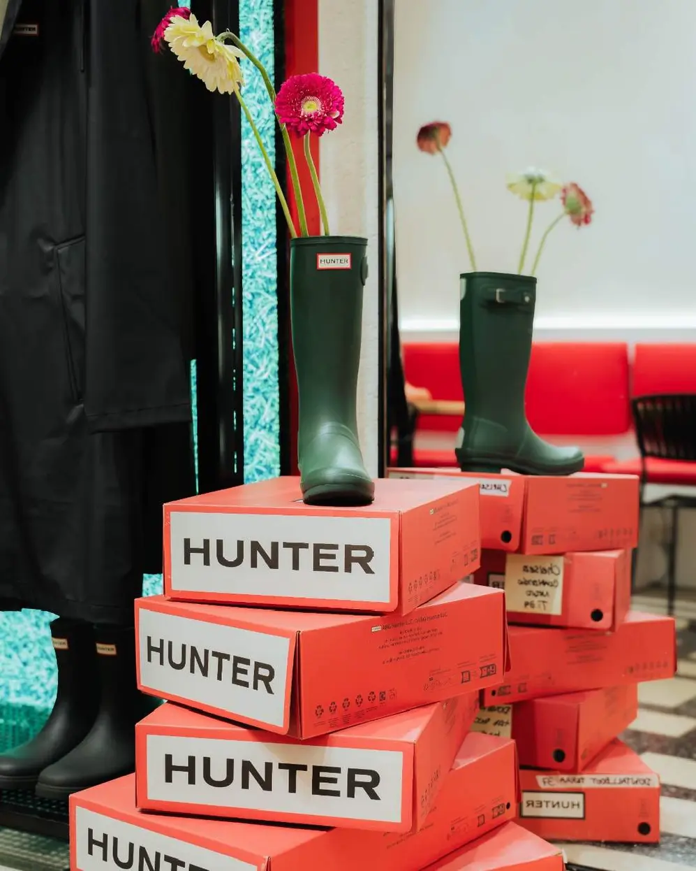 Una bota verde alta de caucho sobre cajas rojas de la marca Hunter