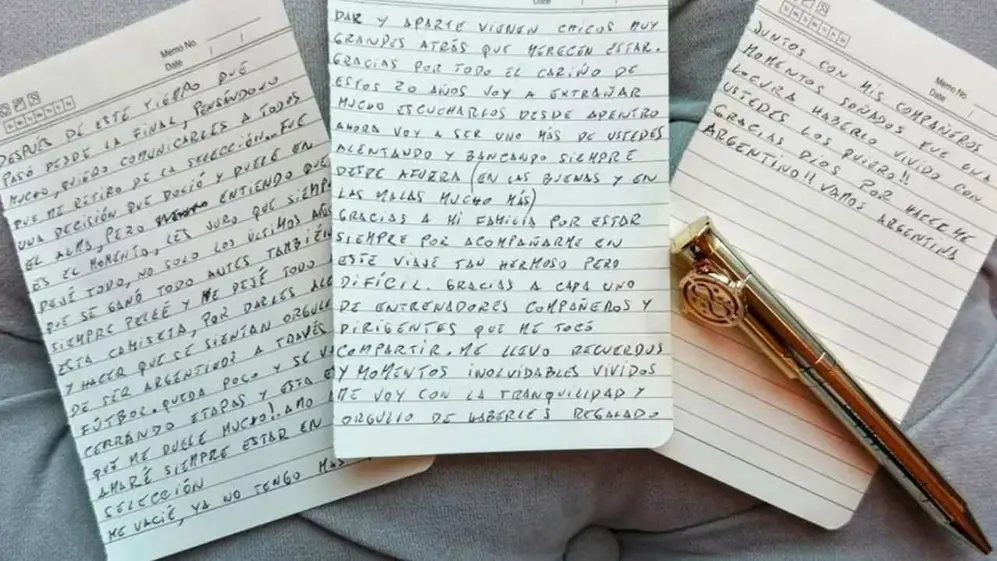 Tres hojas, escritas por Lionel Messi, con una lapicera dorada arriba