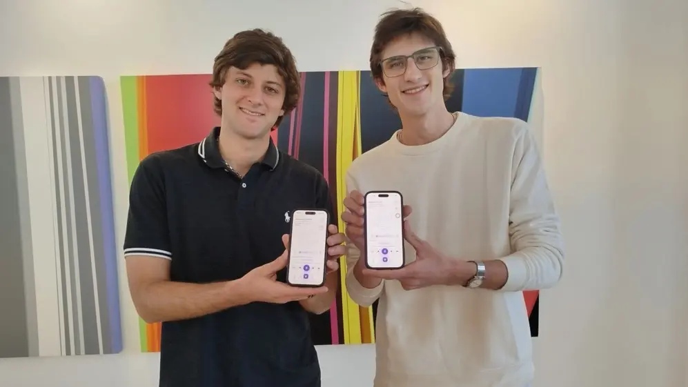 Valentín Virasoro e Iván Schahovskoy mostrando Lisa IA en sus celulares