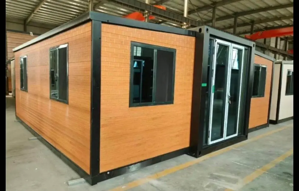 Casa modular prefabricada con revestimiento símil madera, estructura negra y puerta corrediza