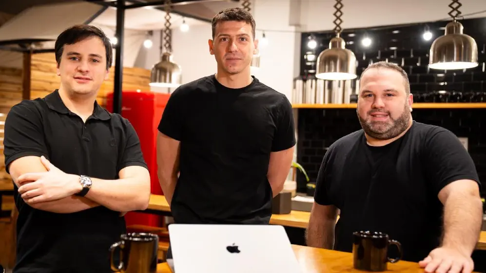 Tomás Marconi, Alejandro Bezdjian y Jesús De Gruttola en una cocina con una notebook mac en el medio