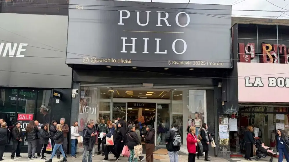 Frente del local de Puro Hilo, con gente haciendo cola y caminando