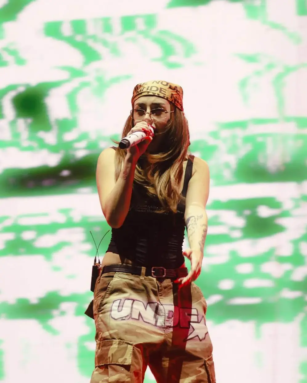 Nicki Nicole cantando arriba de un escenario vestida con ropa y accesorios de la marca Undefined