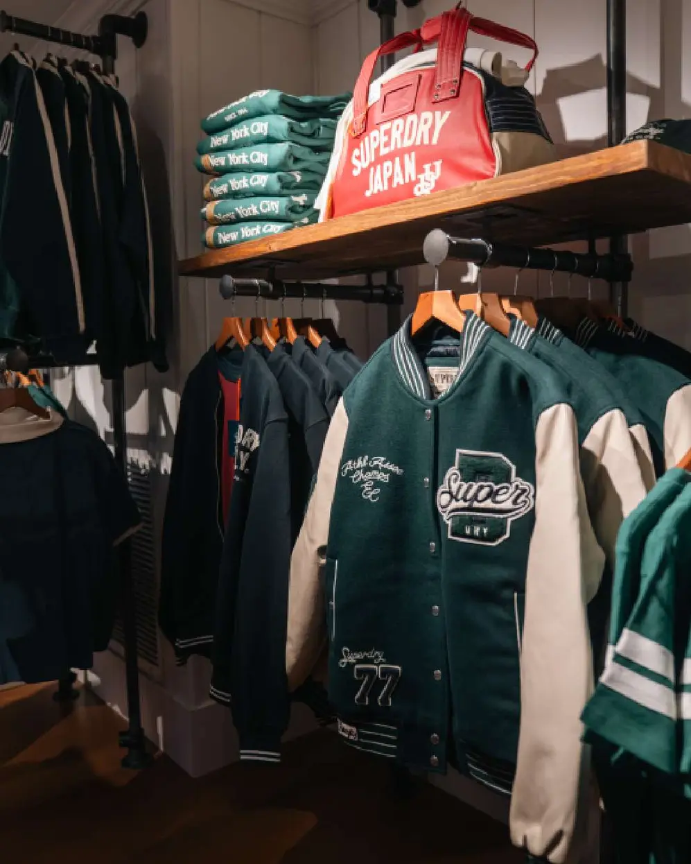 Camperas, ropa y un bolso de la marca Superdry exhibidas en el local de Unicenter