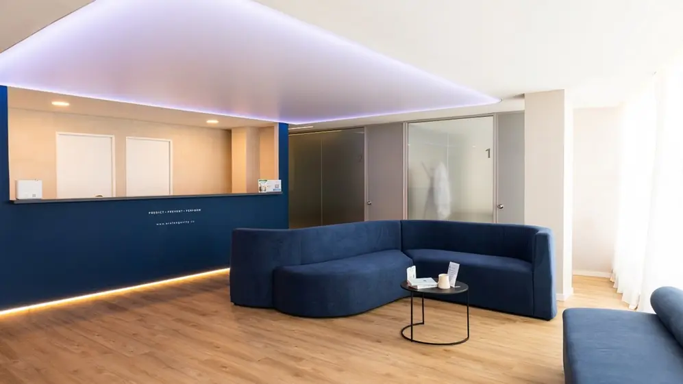 La sala de la clínica con sillones azules y un mostrador amplio