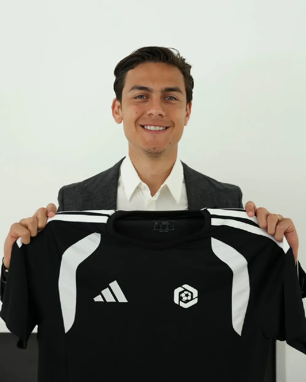 El jugador Paulo Dybala exhibiendo una remera blanca y negra de marca Adidas con el logo de LDP