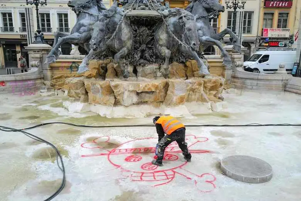 Un empleado municipal limpia la fuente Bartholdi tras los disturbios