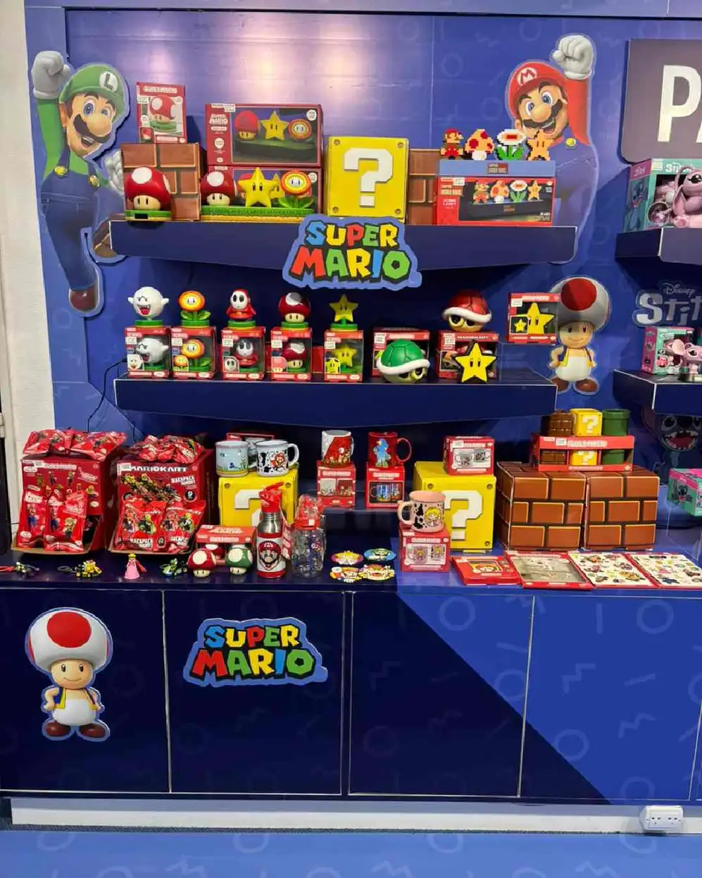 Stand color azul con muñecos, juguetes y objetos de Super MArio
