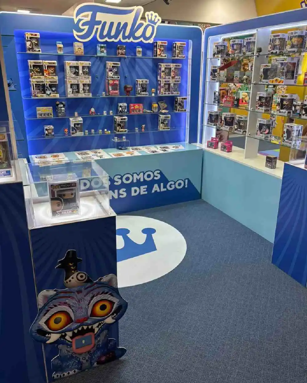 Stand de Funko con muñecos exhibidos en estantes en un espacio donde predomina el color azul
