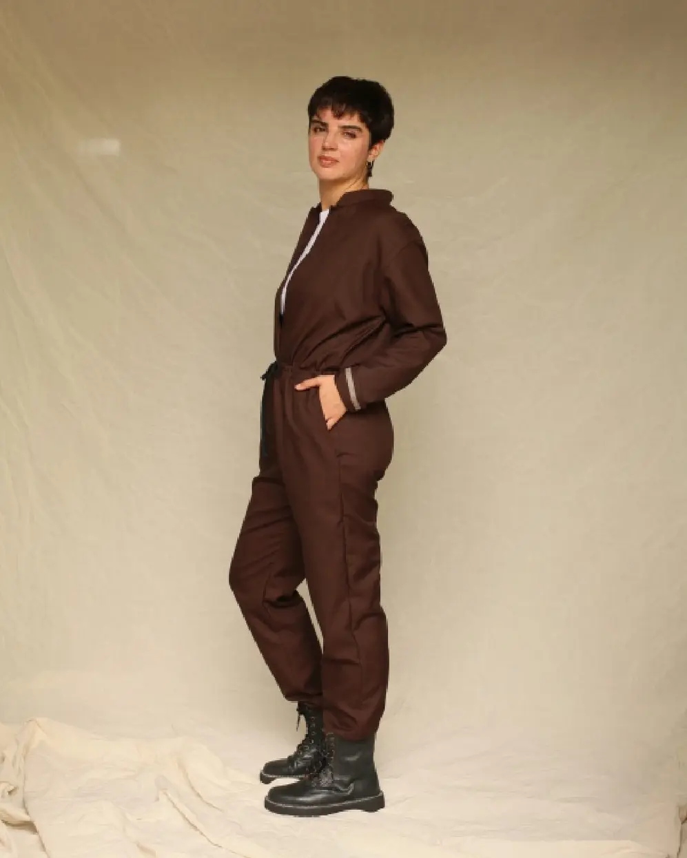 Modelo de pelo corto posa vestida con un conjunto color chocolate y borcegos negros