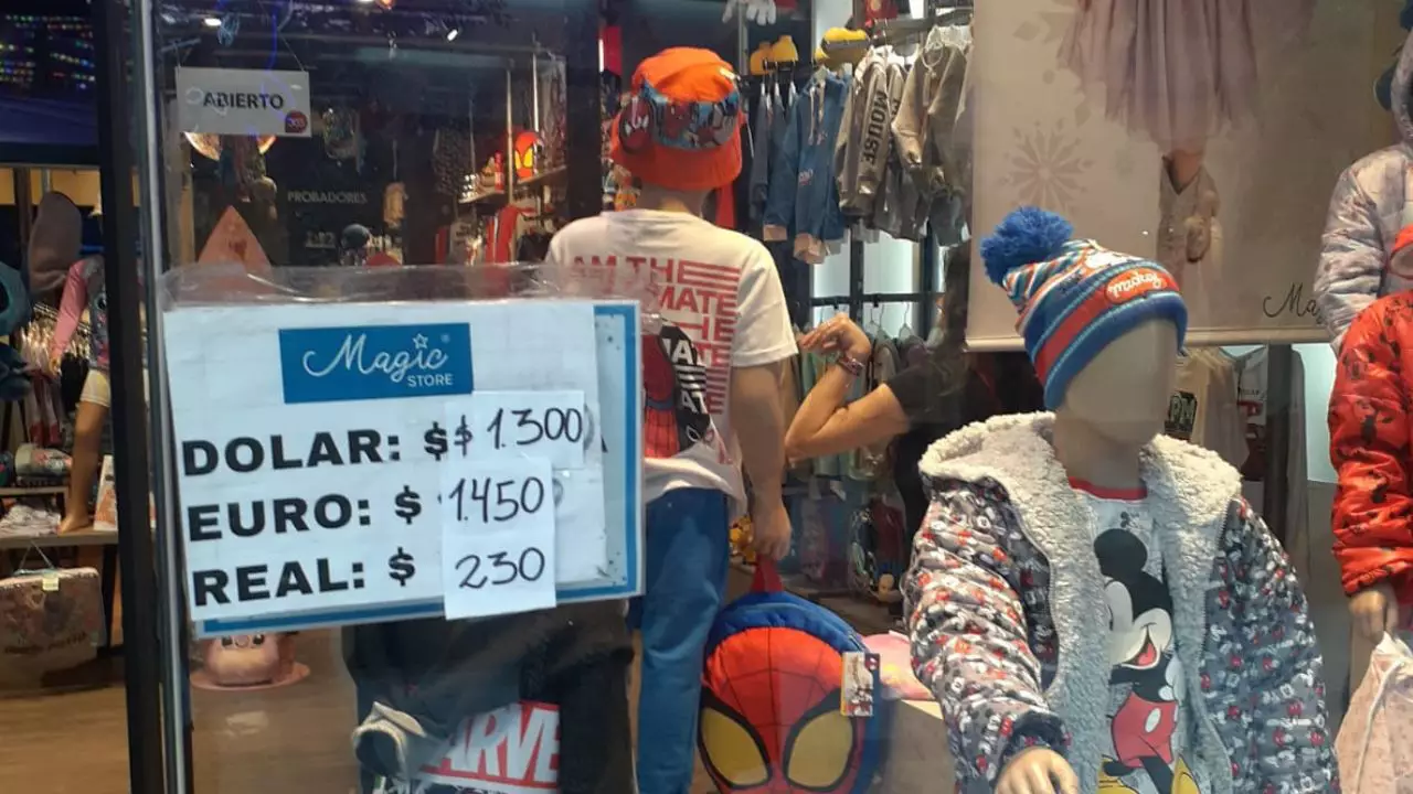 En una casa de ropa para chicos, el valor que se acepta el dólar era $1.300