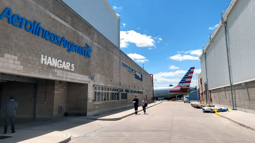 Puerta de entrada al hangar 5 de Ezeiza. Al fondo, estacionado, un Boeing 777 de American Airlines.