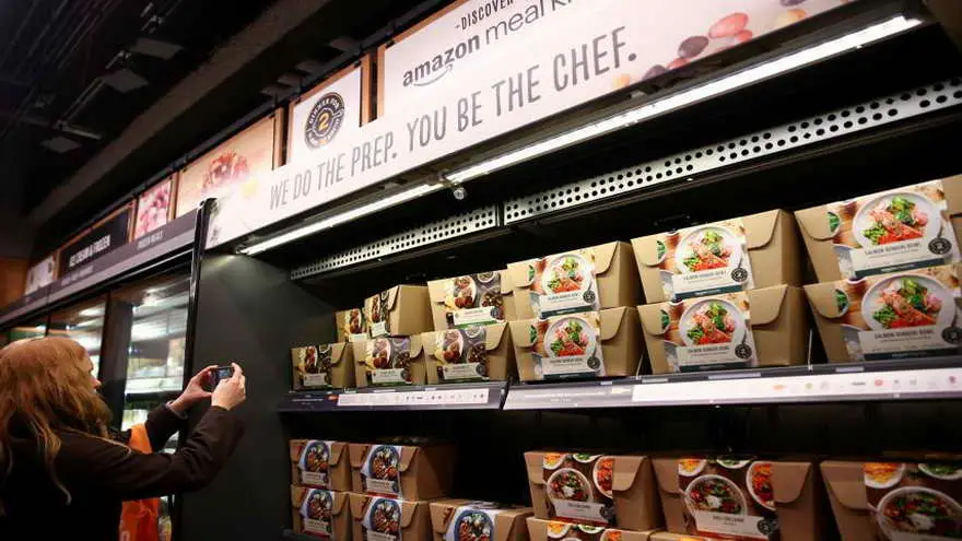 Una mujer hace la compra con el móvil en una tienda de AmazonGo
