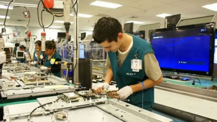 Trabajador de una línea de montaje armando una notebook